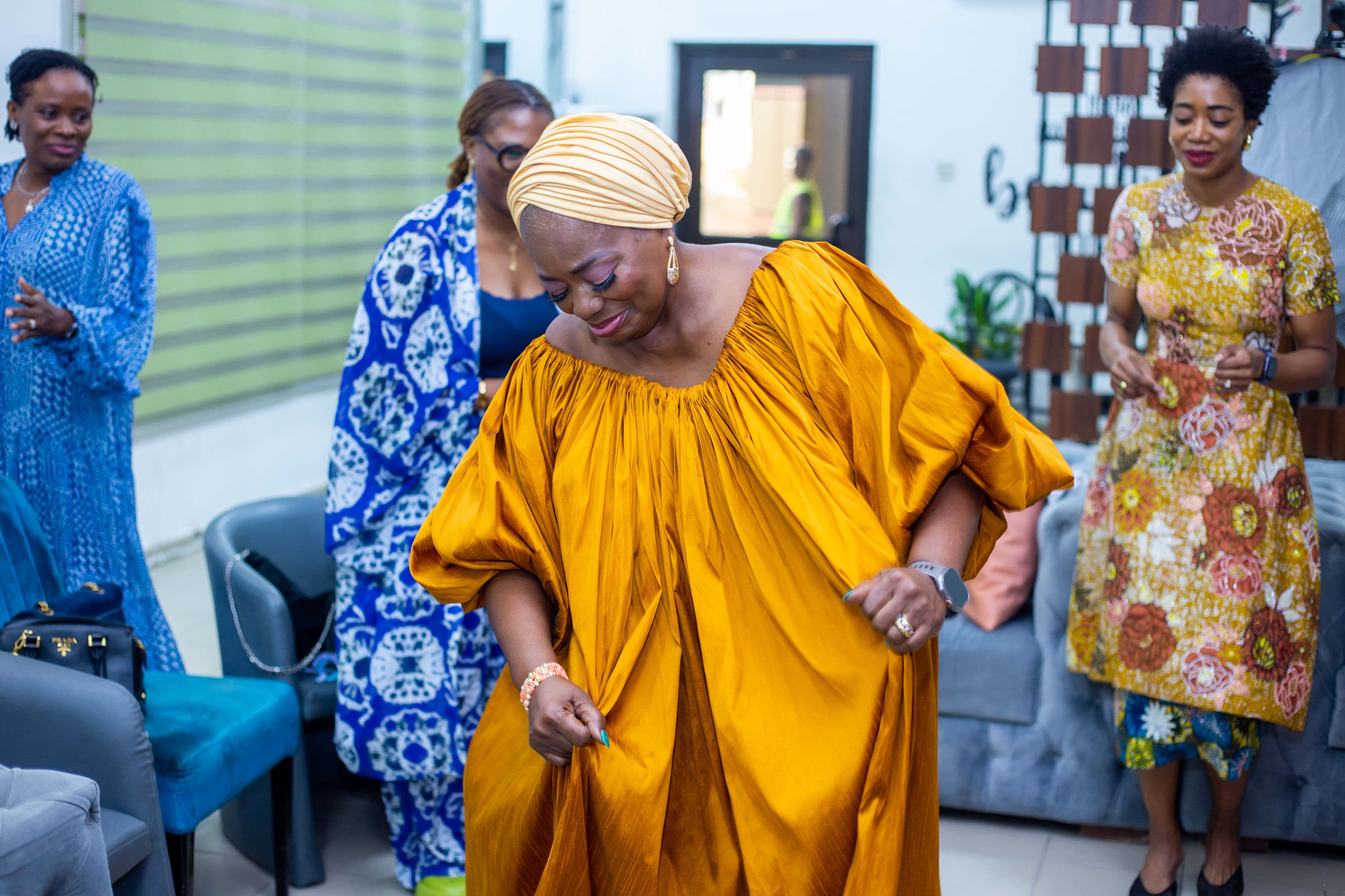 Guest in a flowing gold gown dancing at a wedding reception